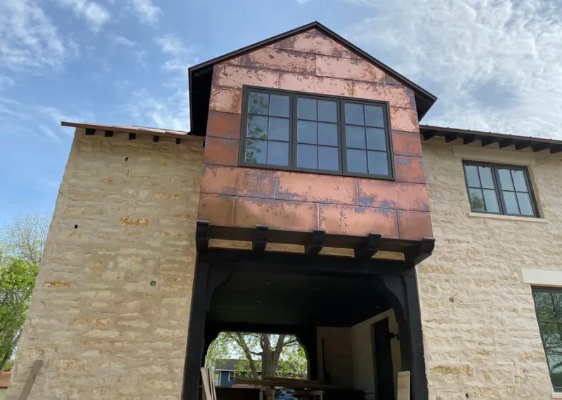 Copper metal panel facade on a stone building for Skylight Installation in Brook Highland