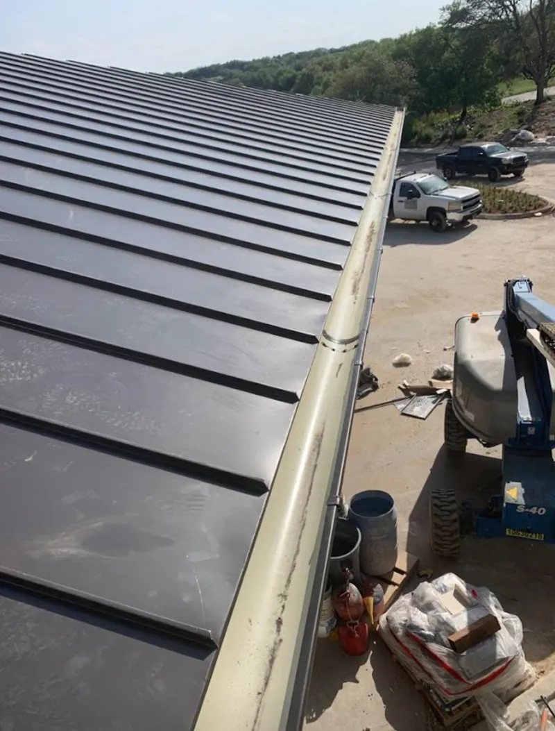 Standing seam panel and gutter detail on a metal roofing jobsite in Brook Highland